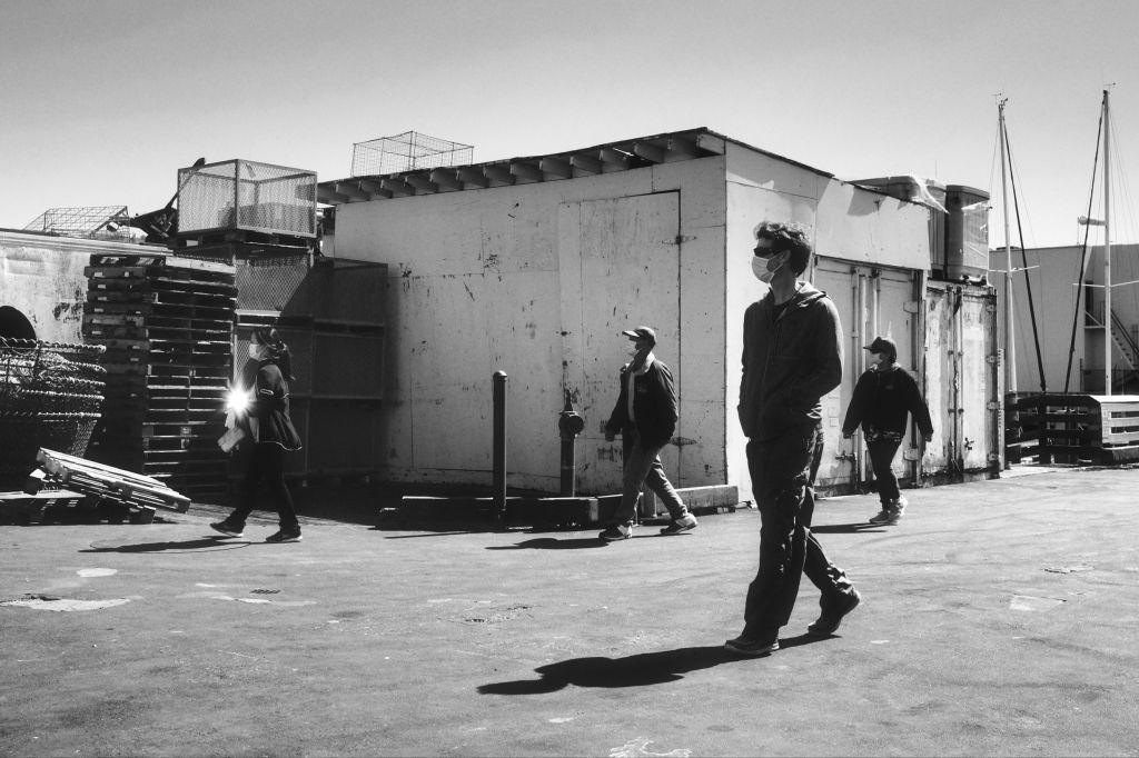 People walking towards fish seller